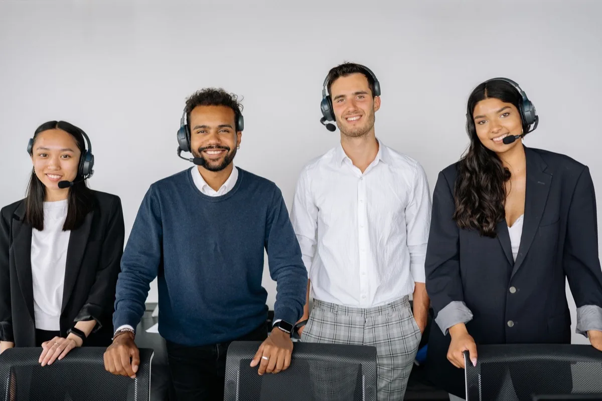 Equipe de atendimento ao cliente com headsets em escritório moderno