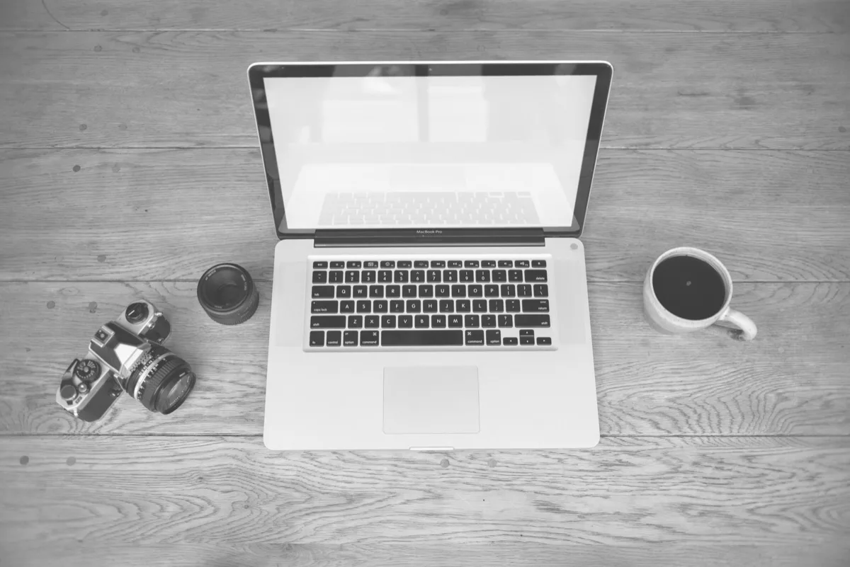 Laptop com xícara de café em mesa de escritório