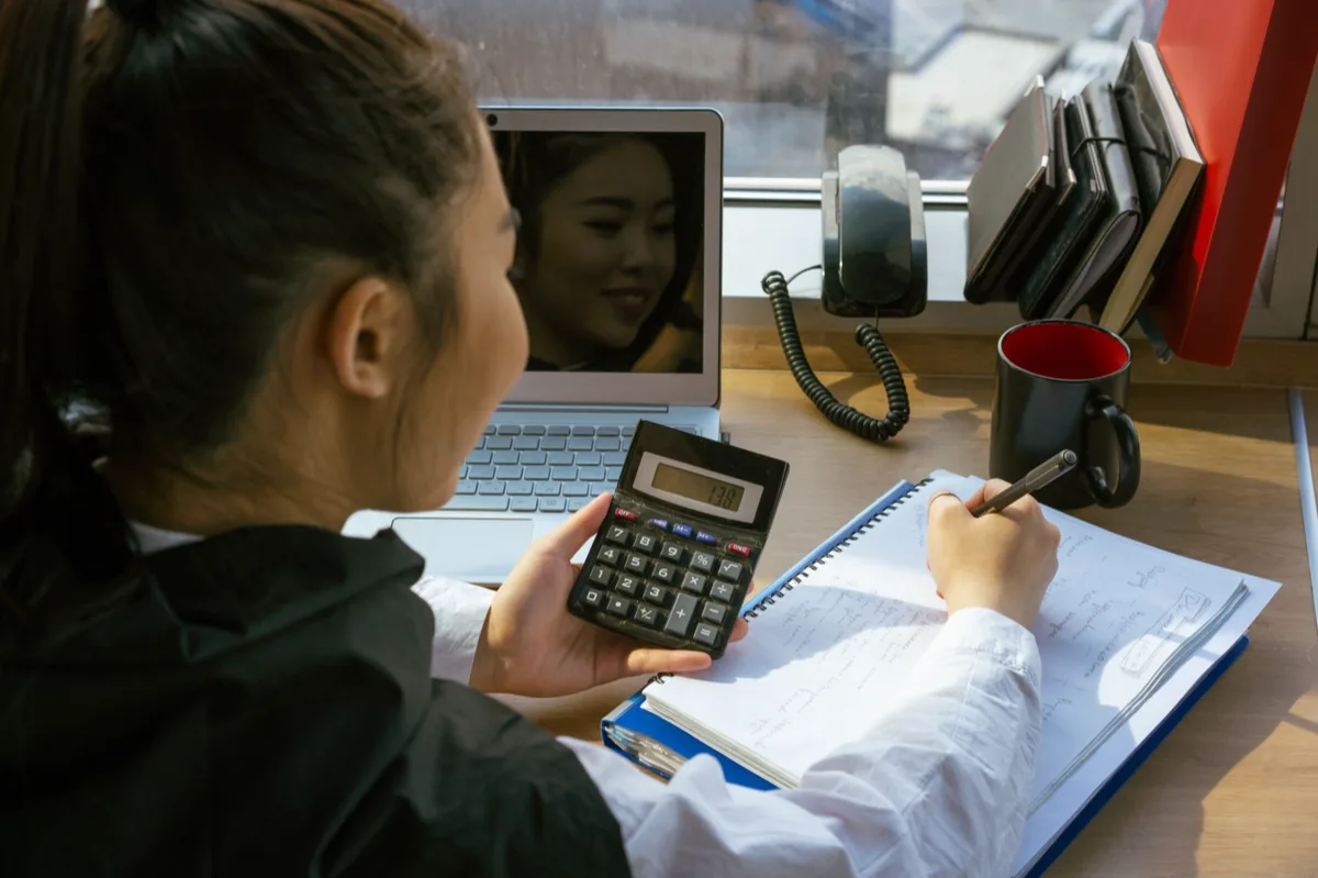 Contador brasileiro calculando despesas com calculadora e café