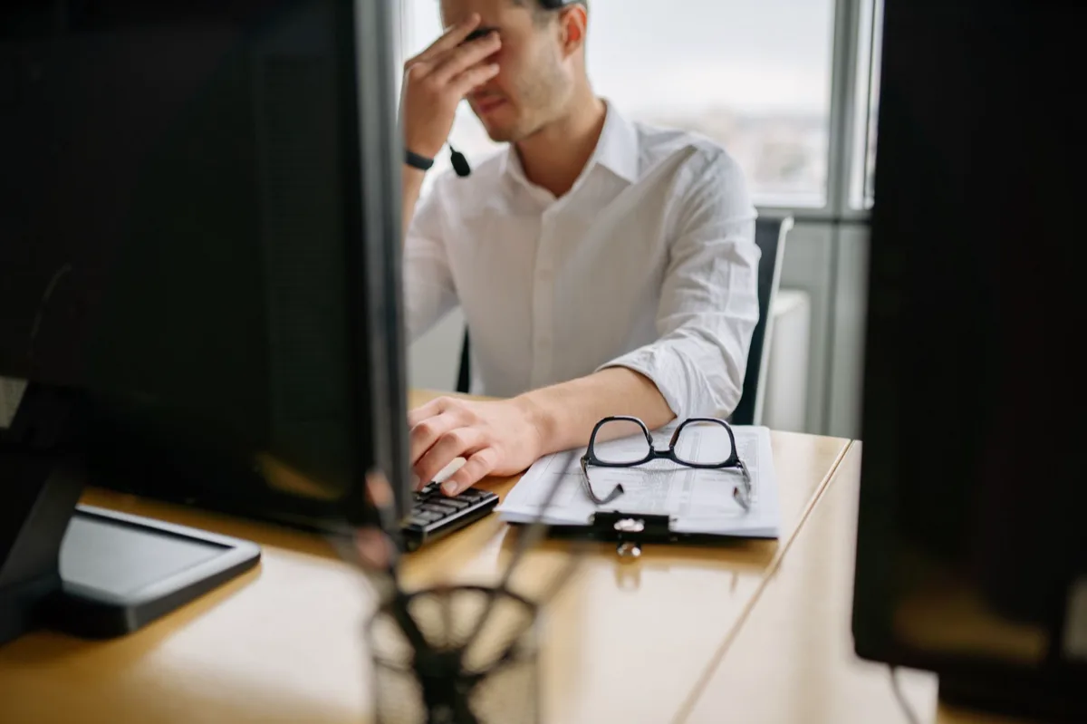 Dois funcionários frustrados em computadores separados