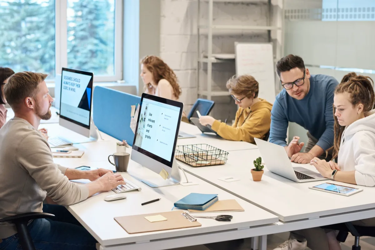 Equipe colaborando em escritório moderno com computadores