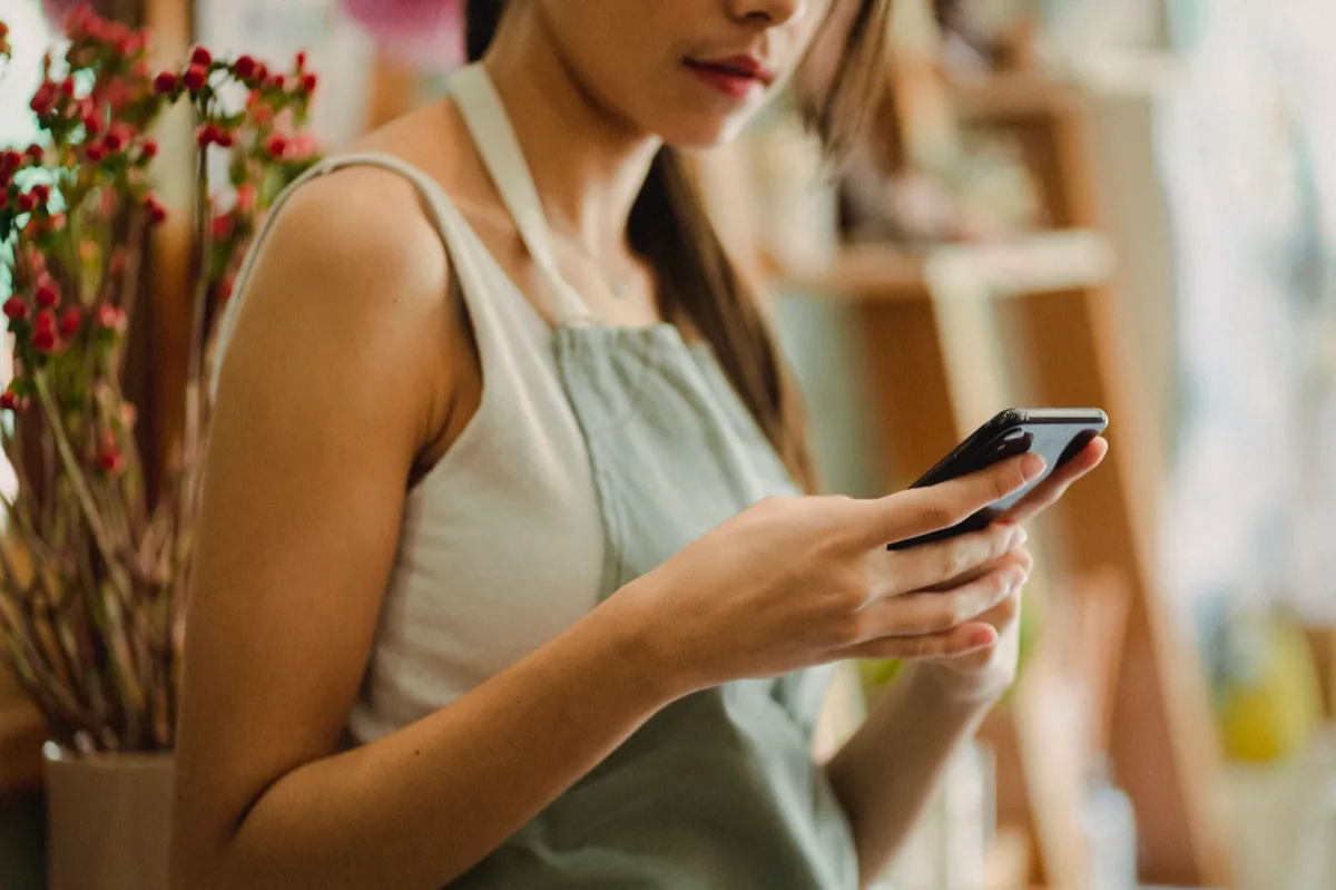 Pequeno empresário usando smartphone para conversar com clientes